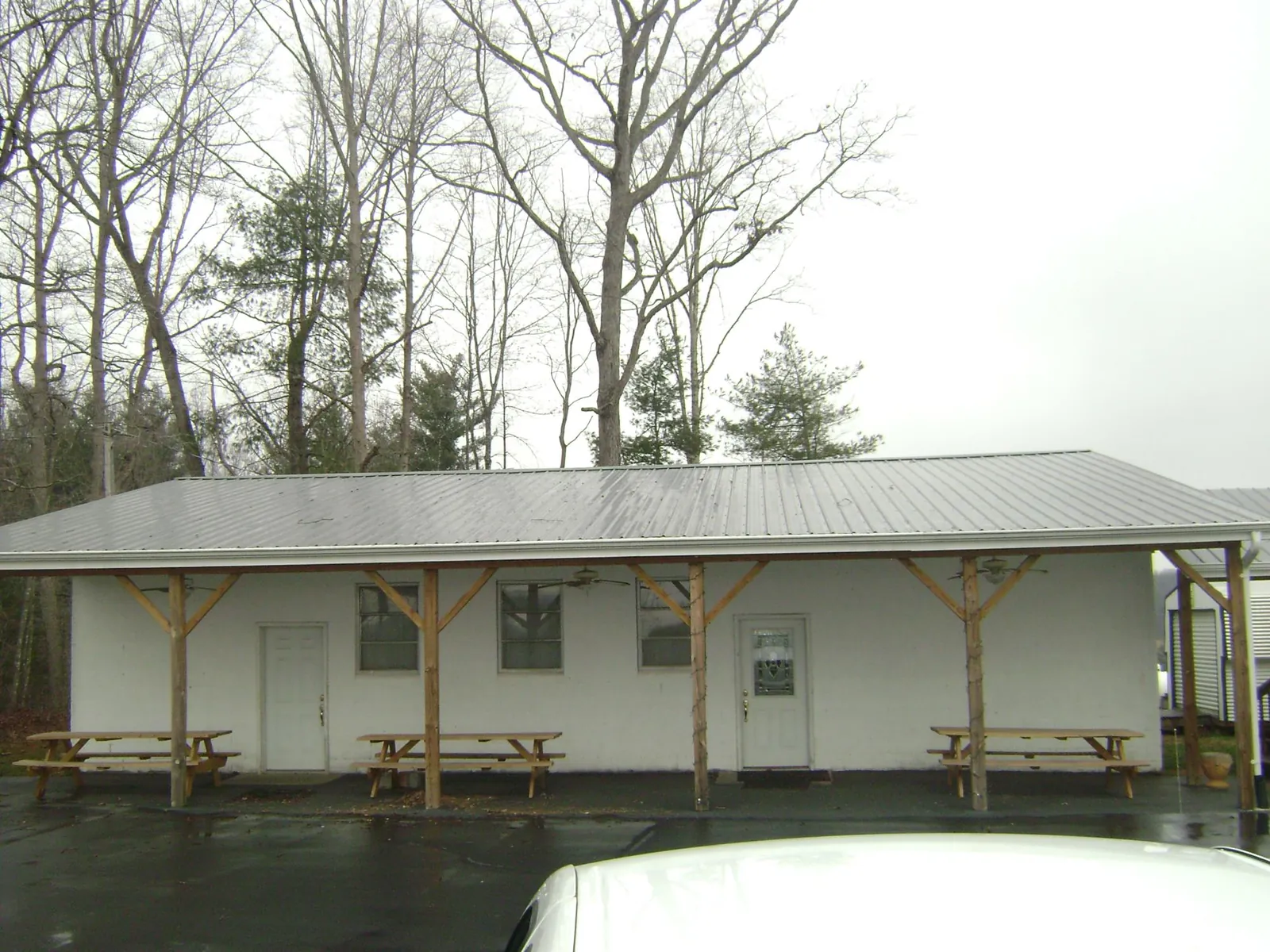 Gray metal roof over a block building with a timber post porch in Woodstock